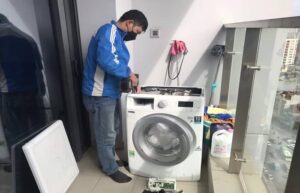 Kỹ thuật viên kiểm tra van cấp nước máy giặt bị tắc cặn tại nhà khách hàng Thanh Xuân